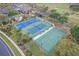 Aerial view showcasing tennis and basketball courts, playground, and community facilities surrounded by green spaces at 4239 Fawn Meadows Cir, Clermont, FL 34711