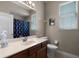 Well-lit bathroom with a vanity, decorative mirror, and nautical shower curtain at 4239 Fawn Meadows Cir, Clermont, FL 34711