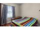 Bright bedroom with hardwood floors, colorful quilt, and window at 4239 Fawn Meadows Cir, Clermont, FL 34711