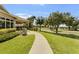 Exterior view of the clubhouse with a walking path and lush landscaping leading to outdoor amenities and green spaces at 4239 Fawn Meadows Cir, Clermont, FL 34711