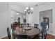 Elegant dining room features a wood table, chandelier and views to office and kitchen at 4239 Fawn Meadows Cir, Clermont, FL 34711
