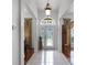 Inviting foyer with decorative glass front door, tile flooring, and elegant light fixture at 4239 Fawn Meadows Cir, Clermont, FL 34711