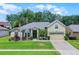 Charming single-story home featuring lush landscaping, mature palm trees, and a welcoming two-car garage at 4239 Fawn Meadows Cir, Clermont, FL 34711