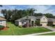 Beautiful front exterior of a home with a well-manicured lawn and tropical landscaping at 4239 Fawn Meadows Cir, Clermont, FL 34711
