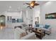 Open-concept living room features tile floors, white sofas, and an adjacent kitchen at 4239 Fawn Meadows Cir, Clermont, FL 34711