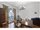 Bright office features hardwood floors, large window, elegant chandelier, and a spacious desk with seating at 4239 Fawn Meadows Cir, Clermont, FL 34711