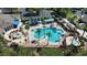 Aerial view of a large community pool with attached spa surrounded by palm trees and lounge seating areas at 4239 Fawn Meadows Cir, Clermont, FL 34711