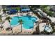Aerial view of a community pool featuring palm trees, lounge chairs, shaded seating and cool, blue, refreshing water at 4239 Fawn Meadows Cir, Clermont, FL 34711