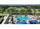 Aerial view of the community pool, spa, seating, and meticulously maintained landscaping and lake view in the distance at 4239 Fawn Meadows Cir, Clermont, FL 34711
