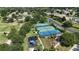 Aerial view of community tennis and basketball courts surrounded by mature trees, green space and residential homes at 4239 Fawn Meadows Cir, Clermont, FL 34711