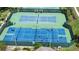 Aerial view of tennis and pickleball courts with sports lighting surrounded by green space at 4239 Fawn Meadows Cir, Clermont, FL 34711