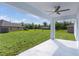 The covered back patio overlooks the expansive green backyard and neighboring houses at 472 Malauka Radl, Ocklawaha, FL 32179