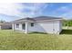 Rear exterior view of the home highlighting the covered patio and spacious backyard at 472 Malauka Radl, Ocklawaha, FL 32179