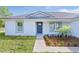 Inviting home exterior with a neatly landscaped yard leading to a stylish blue front door and grey roof at 472 Malauka Radl, Ocklawaha, FL 32179