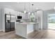 Open concept kitchen featuring stainless appliances, white cabinets, and an island that doubles as a breakfast bar at 472 Malauka Radl, Ocklawaha, FL 32179