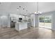 Modern kitchen featuring white cabinetry, a waterfall island, stainless appliances, and sliding glass doors at 472 Malauka Radl, Ocklawaha, FL 32179