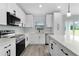 Modern kitchen with stainless steel appliances, white cabinets, and an island that doubles as a breakfast bar at 472 Malauka Radl, Ocklawaha, FL 32179