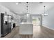 Bright kitchen with stainless appliances, white cabinets, and an island that doubles as a breakfast bar with pendant lighting at 472 Malauka Radl, Ocklawaha, FL 32179