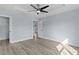 Spacious main bedroom featuring wood grain floors, modern ceiling fan, walk in closet and backyard views at 472 Malauka Radl, Ocklawaha, FL 32179