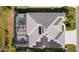 Overhead aerial view of the roof with solar panels and screened-in patio featuring a backyard pool at 4878 Chitty Chatty Run, The Villages, FL 32163