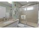 Bathroom with granite countertop sink and a shower over tub with a turtle-themed towel at 4878 Chitty Chatty Run, The Villages, FL 32163