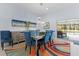 Dining room with modern lighting, colorful rug, and chairs with beautiful tufted blue upholstery at 4878 Chitty Chatty Run, The Villages, FL 32163