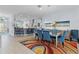 Open dining and kitchen area features a modern table, colorful rug, and seating at kitchen island at 4878 Chitty Chatty Run, The Villages, FL 32163