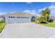 Charming home featuring a three-car garage, light-blue exterior, well-manicured lawn, and decorative driveway at 4878 Chitty Chatty Run, The Villages, FL 32163