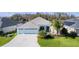 Charming single-story home with a well-manicured lawn, tropical landscaping, and a three-car garage at 4878 Chitty Chatty Run, The Villages, FL 32163