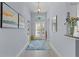 Bright entryway with decorative rug, art, and glass front door leading into the home at 4878 Chitty Chatty Run, The Villages, FL 32163