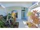 Inviting front porch with lush landscaping, transom window, and stylish glass front door at 4878 Chitty Chatty Run, The Villages, FL 32163
