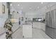 Spacious kitchen features a kitchen island, stainless steel appliances, custom cabinets, and tile backsplash at 4878 Chitty Chatty Run, The Villages, FL 32163