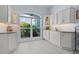 Bright kitchen with custom cabinets, large window offering plenty of light and view of lush garden at 4878 Chitty Chatty Run, The Villages, FL 32163