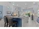 Bright kitchen features pendant lighting, island seating, stainless steel appliances, and tile backsplash at 4878 Chitty Chatty Run, The Villages, FL 32163