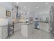 Well-lit kitchen with stainless steel appliances, tile backsplash, kitchen island, and decorative pendant lights at 4878 Chitty Chatty Run, The Villages, FL 32163