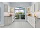 Bright kitchen with custom cabinets, large window offering plenty of light and view of lush garden at 4878 Chitty Chatty Run, The Villages, FL 32163