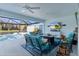 Relaxing lanai area with comfortable seating, a TV, and scenic views of the pool and lush backyard at 4878 Chitty Chatty Run, The Villages, FL 32163