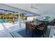 Outdoor living space featuring a dining area, comfortable seating, and pool with views of the water at 4878 Chitty Chatty Run, The Villages, FL 32163