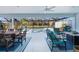 Covered lanai featuring an outdoor kitchen, a dining area, comfortable seating, and a spa-like pool with lake views at 4878 Chitty Chatty Run, The Villages, FL 32163