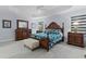 Elegantly furnished main bedroom with a decorative wood frame bed and wood flooring at 4878 Chitty Chatty Run, The Villages, FL 32163