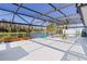 Expansive screened lanai with serene pond views, palm trees, and stylish decor at 4878 Chitty Chatty Run, The Villages, FL 32163