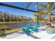 Screened outdoor lanai with comfortable seating and a serene pond view at 4878 Chitty Chatty Run, The Villages, FL 32163