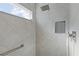 Modern shower featuring gray tile, a shower niche, and a window that provides natural light at 4878 Chitty Chatty Run, The Villages, FL 32163