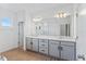 Bathroom with double vanity, a large mirror, and wood look floors at 5107 Marshelder St, Apopka, FL 32712
