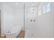 Modern bathroom featuring a soaking tub, glass enclosed shower, and tiled floors at 5107 Marshelder St, Apopka, FL 32712