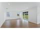 Bright living room with wood-look tile floors, modern recessed lighting, and sliding glass door at 5107 Marshelder St, Apopka, FL 32712