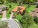 Aerial view of a beautiful home with terracotta roof, screened pool, and lush, mature landscaping at 5235 Island Terrace Ct, Lady Lake, FL 32159