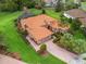 Beautiful aerial view of home showcasing terra cotta roof, green lawn, brick driveway, and mature landscaping at 5235 Island Terrace Ct, Lady Lake, FL 32159