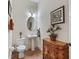 Powder room with a pedestal sink, decorative mirror, and cabinet at 5235 Island Terrace Ct, Lady Lake, FL 32159