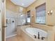 Bathroom showcasing a soaking tub, separate shower, and window at 5235 Island Terrace Ct, Lady Lake, FL 32159